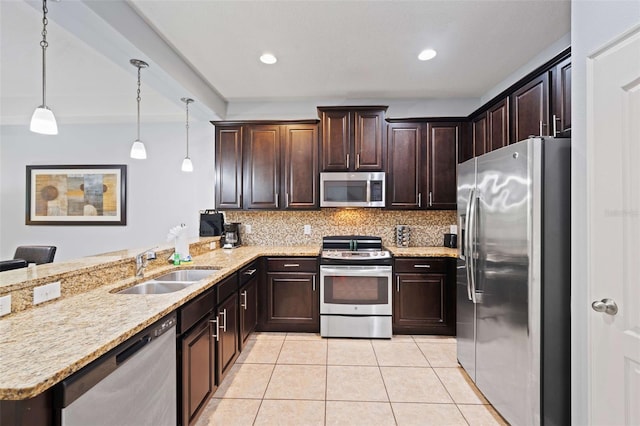 kitchen with kitchen peninsula, stainless steel appliances, sink, dark brown cabinetry, and decorative light fixtures