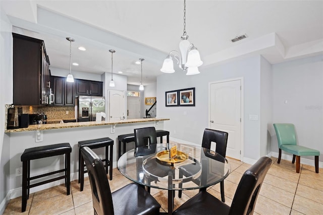 dining area featuring a chandelier and light tile patterned floors