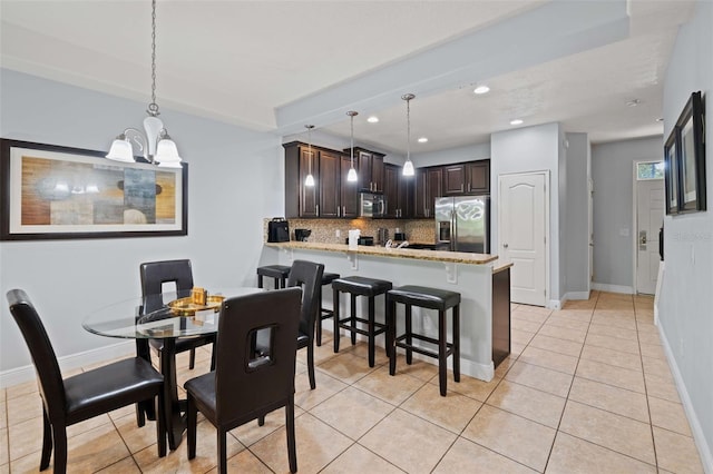 tiled dining space featuring a chandelier