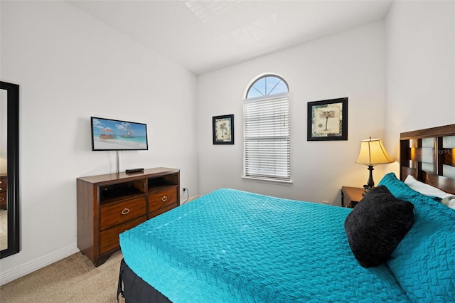 carpeted bedroom with lofted ceiling