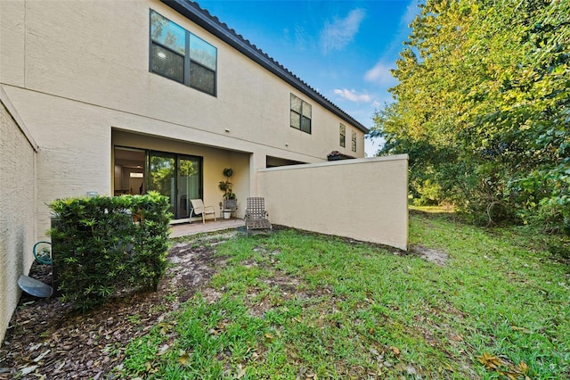 rear view of property featuring a patio area and a lawn