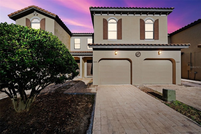8091 Brooksville Dr, Davenport, FL 33896 - mediterranean / spanish-style house with a garage, stucco siding, decorative driveway, and a tiled roof