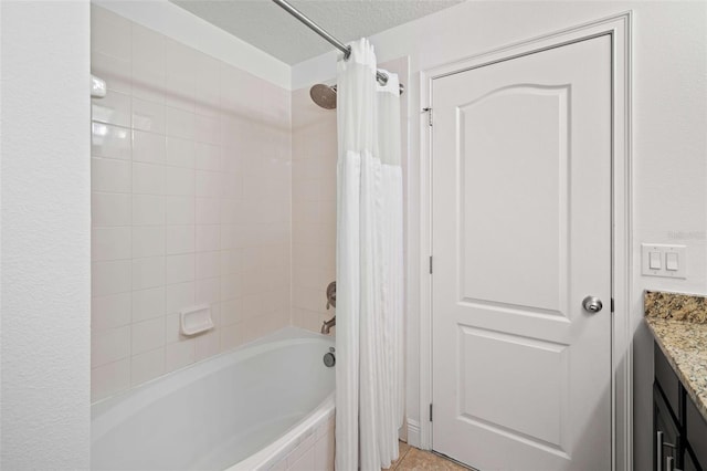 bathroom featuring vanity, a textured ceiling, shower / bath combination with curtain, and tile patterned flooring