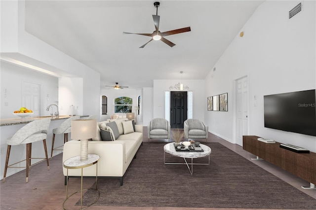 living room with dark hardwood / wood-style flooring, high vaulted ceiling, and ceiling fan