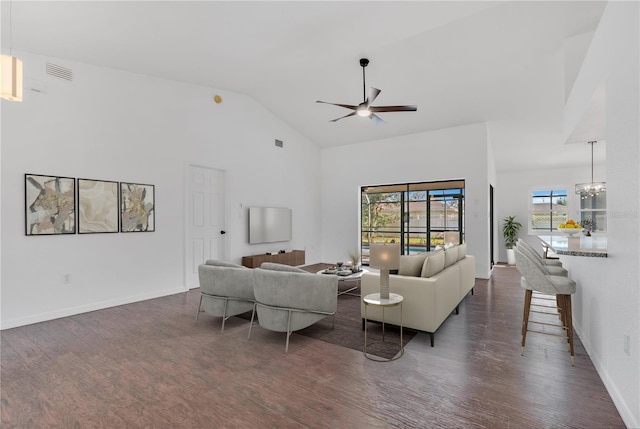 living room featuring dark hardwood / wood-style flooring, ceiling fan with notable chandelier, and vaulted ceiling