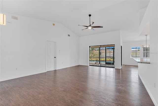 unfurnished living room with ceiling fan with notable chandelier, dark hardwood / wood-style floors, and high vaulted ceiling