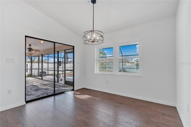 spare room with ceiling fan with notable chandelier and dark wood-type flooring