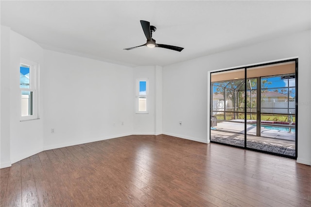 spare room with ceiling fan, a healthy amount of sunlight, and dark hardwood / wood-style floors