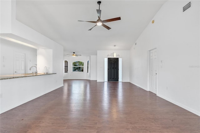 unfurnished living room with vaulted ceiling, ceiling fan, and dark wood-type flooring