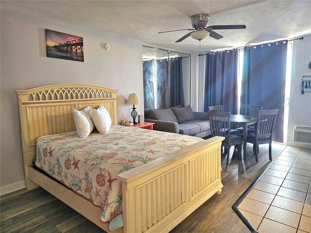 1233 S Atlantic Ave Unit 5270, Daytona Beach, FL 32118 - bedroom featuring an AC wall unit, a textured ceiling, a ceiling fan, baseboards, and wood finished floors