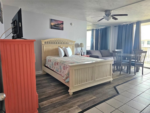 bedroom with ceiling fan, a textured ceiling, and dark hardwood / wood-style floors