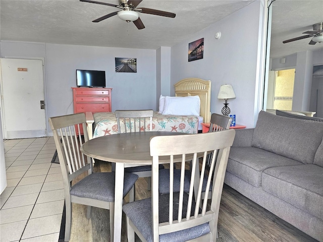 dining space with wood-type flooring, ceiling fan, and a textured ceiling