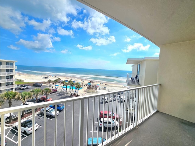 balcony with a water view and a beach view