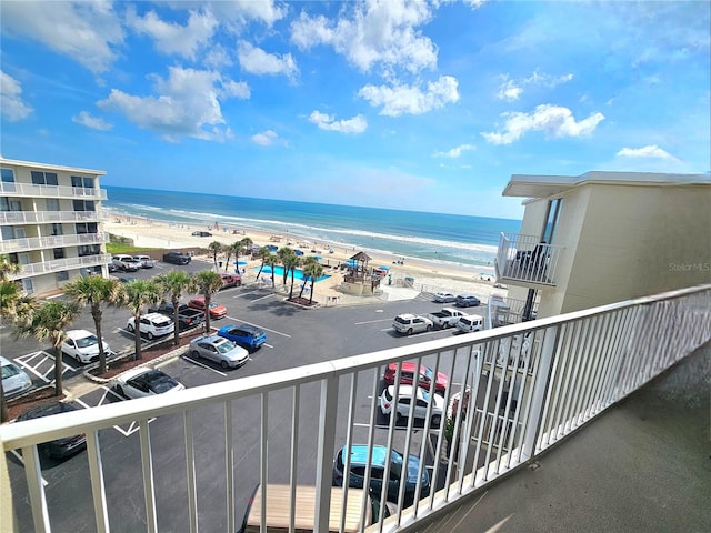 balcony featuring a view of the beach and a water view