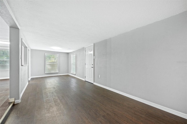 empty room featuring a textured ceiling and dark hardwood / wood-style floors