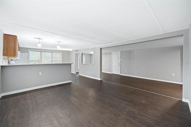 unfurnished living room with dark hardwood / wood-style flooring and sink