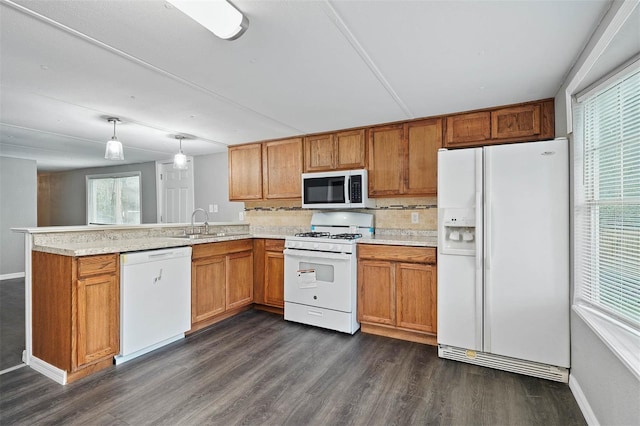 kitchen with hanging light fixtures, decorative backsplash, dark wood-type flooring, white appliances, and kitchen peninsula