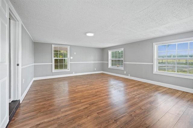 empty room featuring wood-type flooring and a textured ceiling