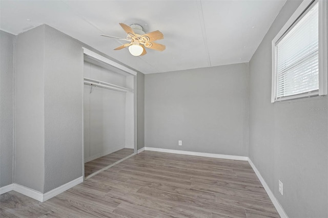 unfurnished bedroom with ceiling fan, a closet, and light hardwood / wood-style flooring