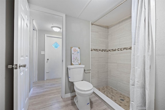 bathroom featuring walk in shower, hardwood / wood-style flooring, and toilet