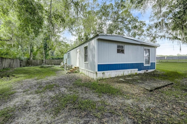 view of side of home featuring a yard and central AC unit