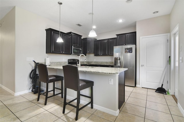 1209 Seburn Rd, Apopka, FL 32703 - kitchen featuring stainless steel appliances, a peninsula, dark cabinets, light tile patterned flooring, and light stone countertops