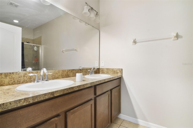 bathroom with tile patterned flooring, a shower with door, and vanity