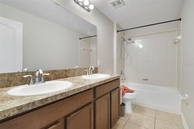 full bathroom featuring vanity, tiled shower / bath combo, tile patterned flooring, a textured ceiling, and toilet