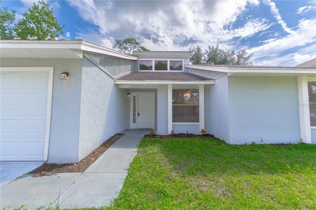 entrance to property with a lawn and a garage