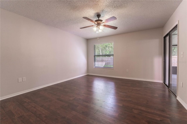 spare room featuring dark wood-type flooring, ceiling fan, and a textured ceiling