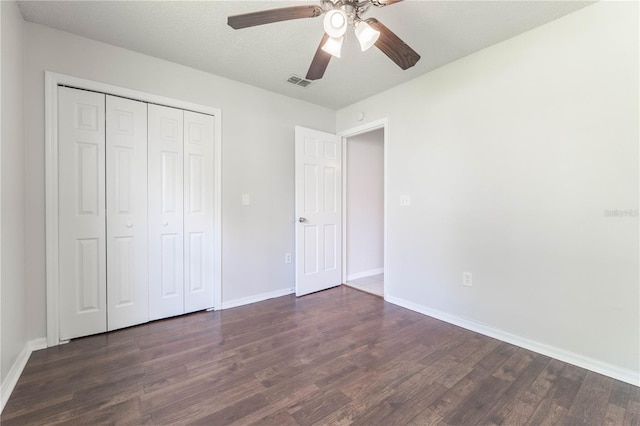 unfurnished bedroom with a textured ceiling, dark hardwood / wood-style floors, a closet, and ceiling fan