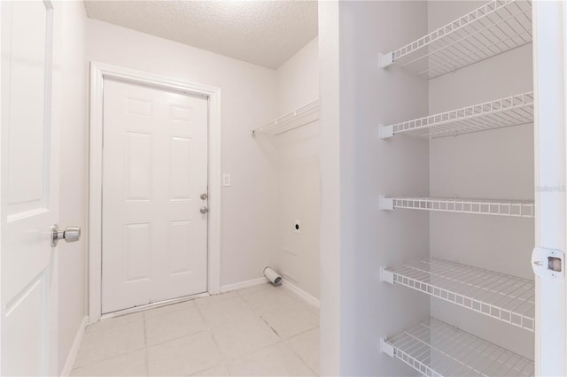 laundry area with electric dryer hookup and a textured ceiling