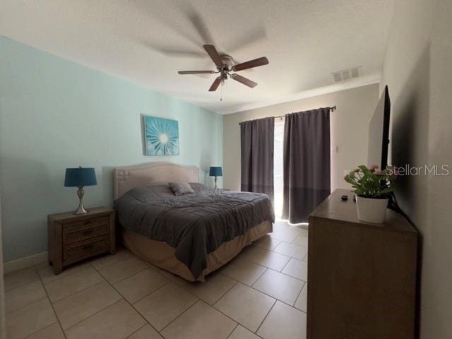 bedroom with baseboards, visible vents, light tile patterned floors, and ceiling fan
