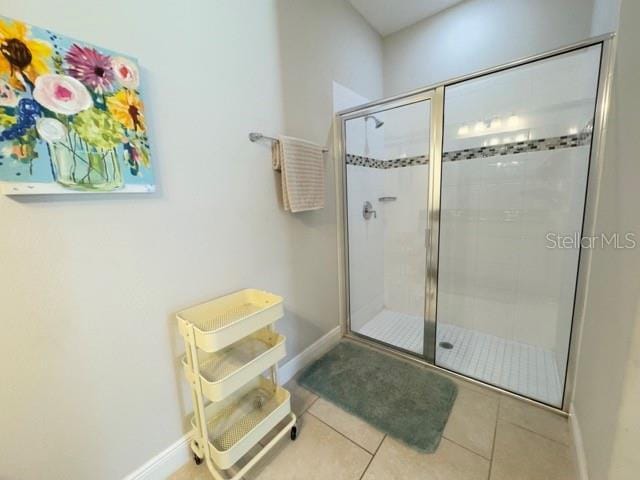full bathroom with tile patterned flooring, a stall shower, and baseboards