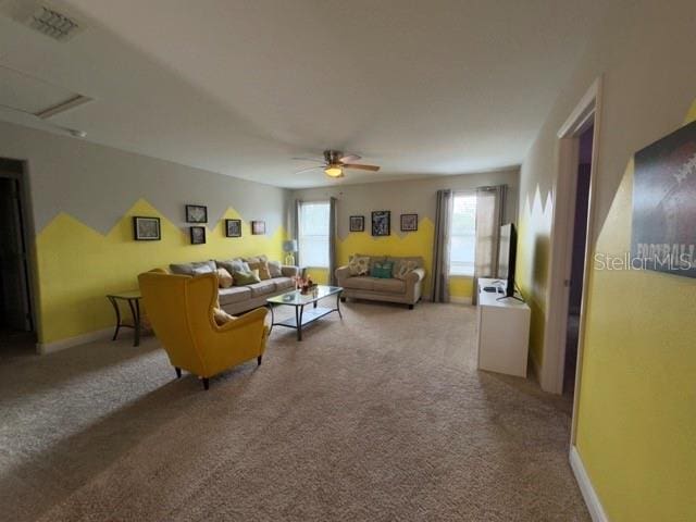living area with a ceiling fan, carpet flooring, and baseboards
