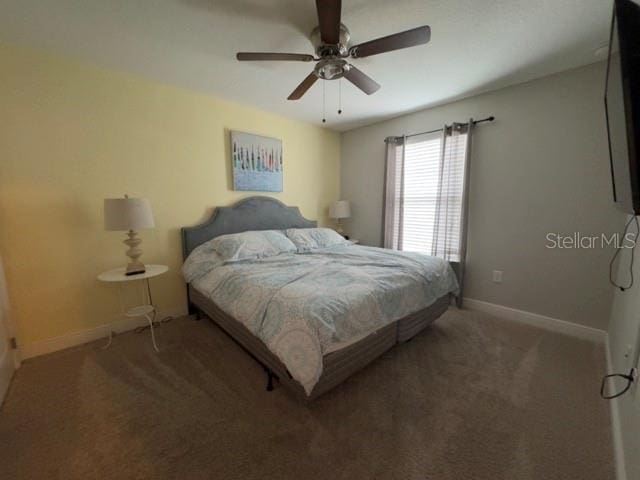 carpeted bedroom featuring baseboards and ceiling fan