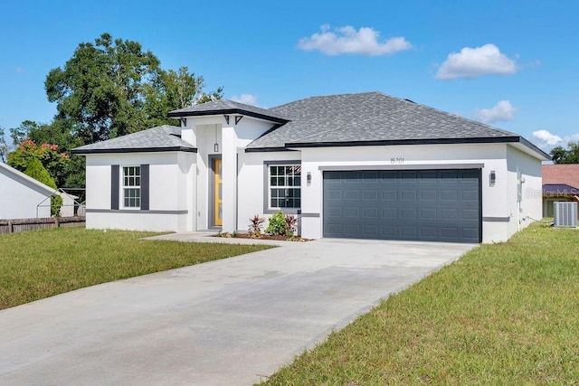 view of front of house featuring central air condition unit, a front lawn, and a garage