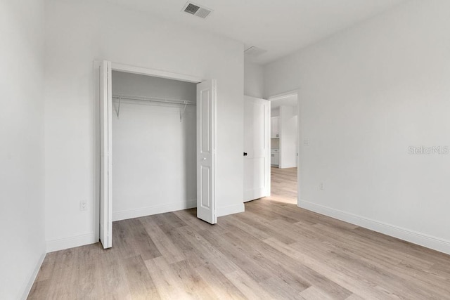 unfurnished bedroom featuring a closet and light hardwood / wood-style flooring