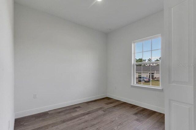 unfurnished room with hardwood / wood-style flooring