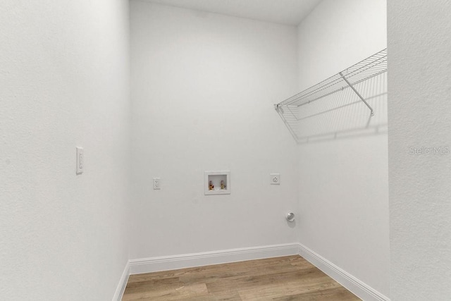 clothes washing area with hookup for an electric dryer, hookup for a washing machine, and hardwood / wood-style flooring