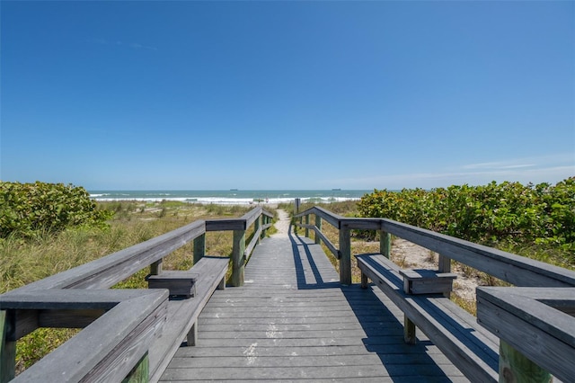 view of community with a water view and a beach view