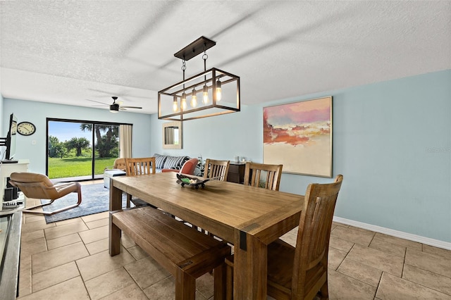 tiled dining area with ceiling fan and a textured ceiling