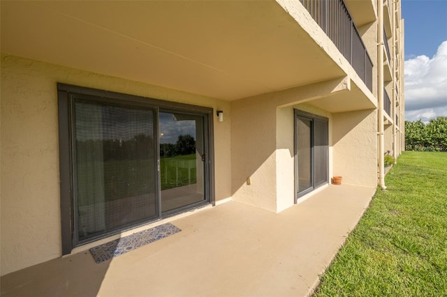 view of exterior entry featuring a yard