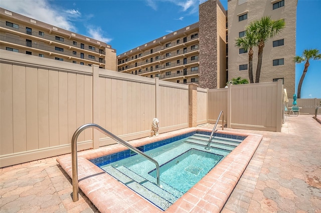 view of swimming pool featuring a hot tub