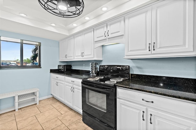 kitchen with black appliances, light tile patterned floors, white cabinets, dark stone counters, and a tray ceiling