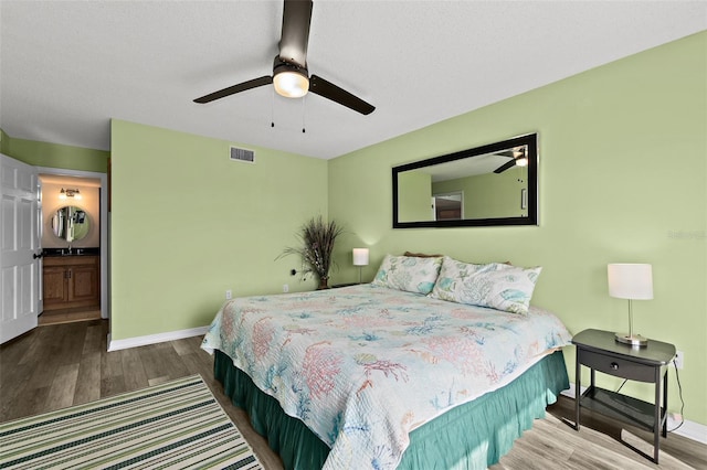 bedroom with ceiling fan, connected bathroom, and wood-type flooring