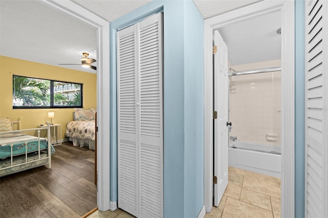 hallway with light tile patterned floors and a textured ceiling