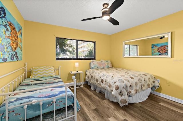 bedroom with wood-type flooring, multiple windows, a textured ceiling, and ceiling fan