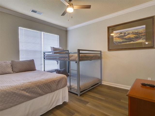 bedroom with ornamental molding, dark hardwood / wood-style flooring, and ceiling fan