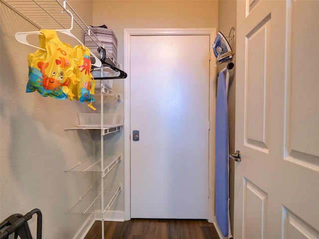 walk in closet with dark hardwood / wood-style flooring